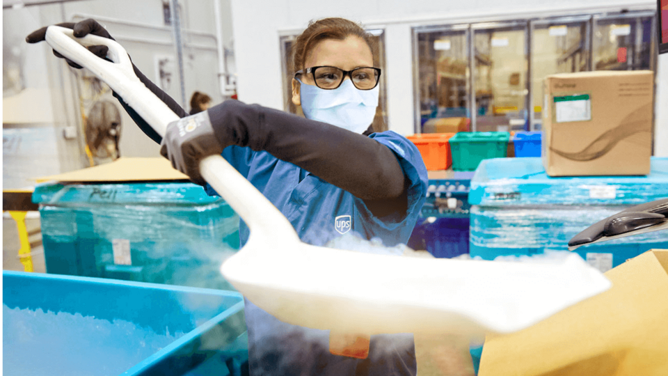 A UPS team member shovelling dry ice into a thermal package